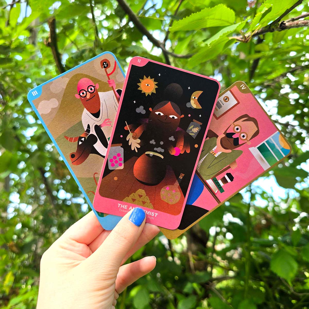 Folk-inspired recycled uncoated tarot-style cards with rounded corners, colourful character illustrations, symbolic details and earthy muted tones.