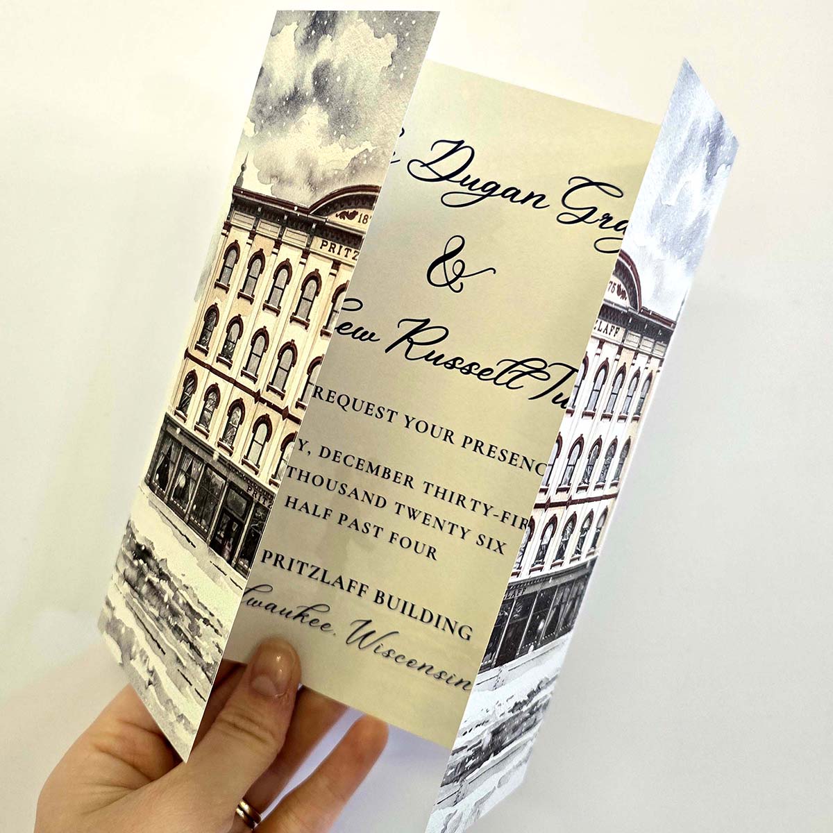 Tintoretto Gesso gate fold wedding invitation with illustrated Pritzlaff Building panels, script typography and textured folded card stock.